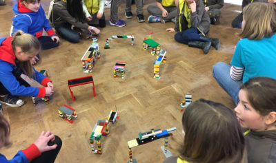 Guides, brownies and rangers gathered round different model bridges made of Lego